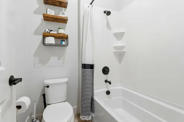 a bathroom with a toilet and a shower