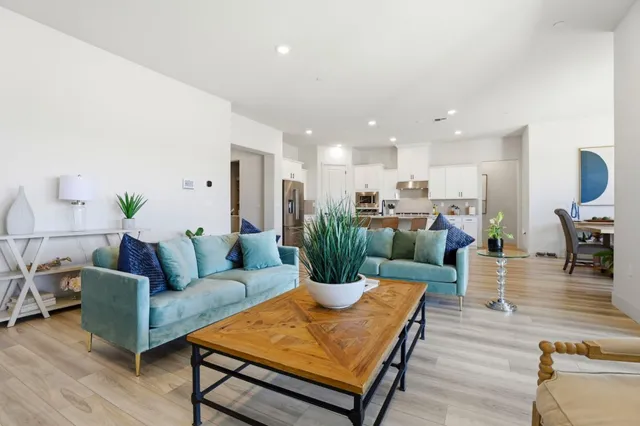 a living room with furniture kitchen view and a dining table