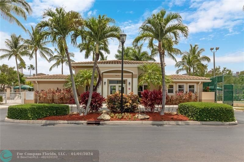 9525 Weldon Circle, Unit H110 Tamarac, FL 33321 - Photo 18 of 20 front view of a house with a yard and palm trees