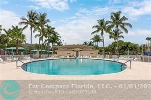 9525 Weldon Circle, Unit H110 Tamarac, FL 33321 - Photo 19 of 20 a view of a swimming pool with a garden