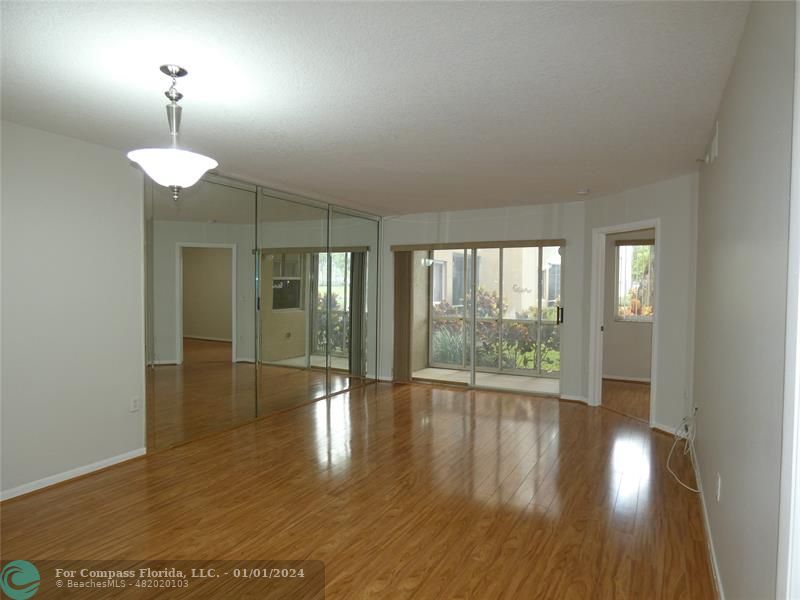 9525 Weldon Circle, Unit H110 Tamarac, FL 33321 - Photo 10 of 20 a view of an empty room with wooden floor and a window