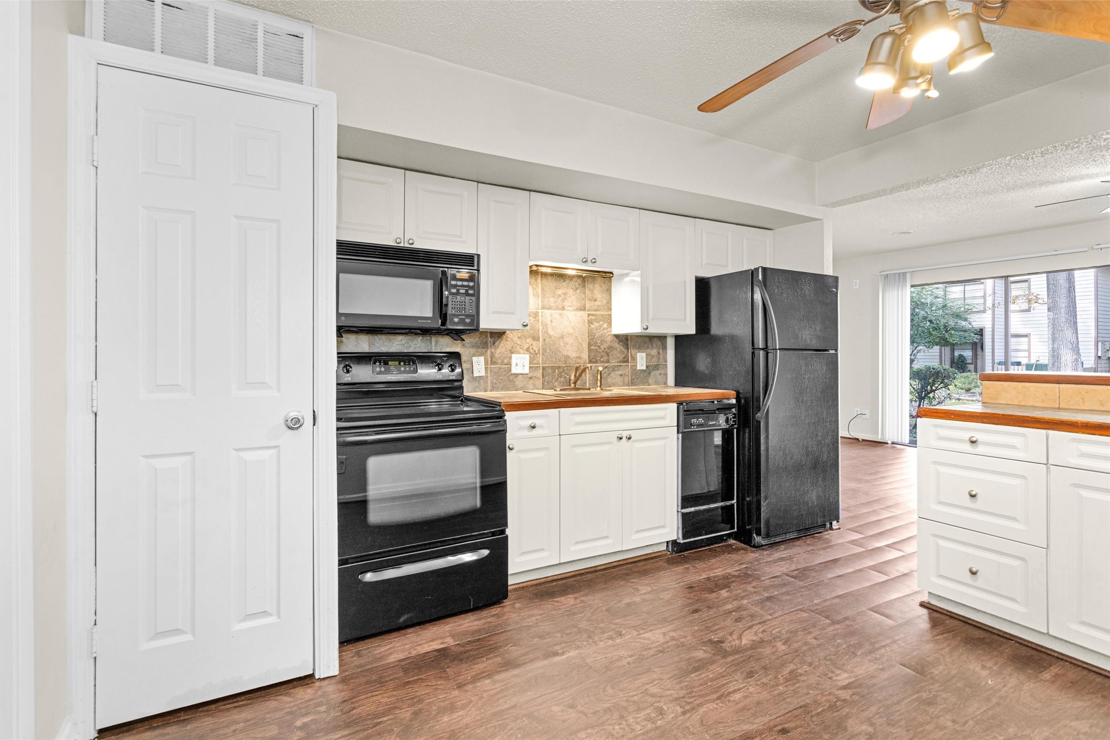 12900 Walden Road, Unit 513 Montgomery, TX 77356 - Photo 3 of 20 a kitchen with white cabinets and stainless steel appliances