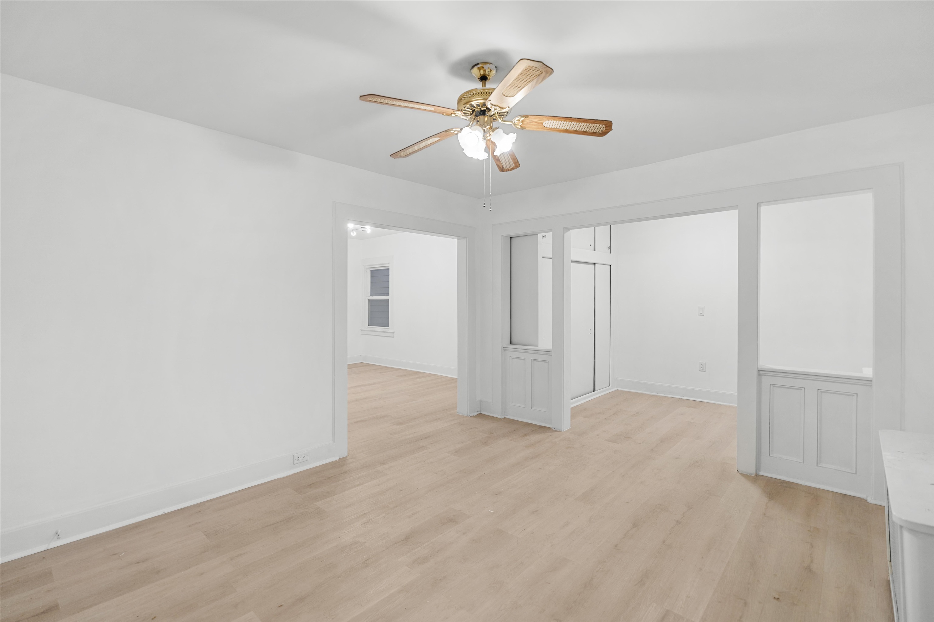 an empty room with fan and windows