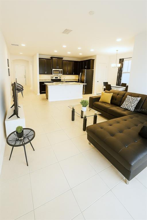 181 Trinity Ridge Circle Davenport, FL 33897 - Photo 2 of 10 a living room with kitchen island furniture and a chandelier