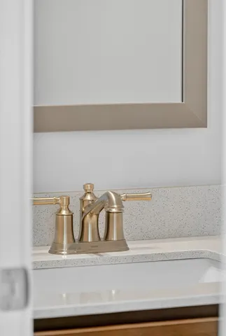 a kitchen with white cabinets and sink
