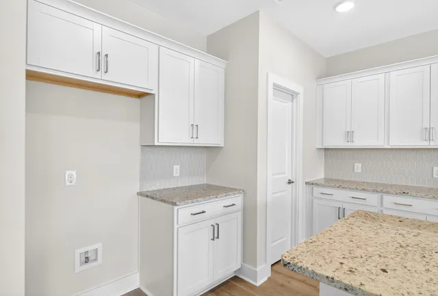 a kitchen with granite countertop a sink a stove and a microwave