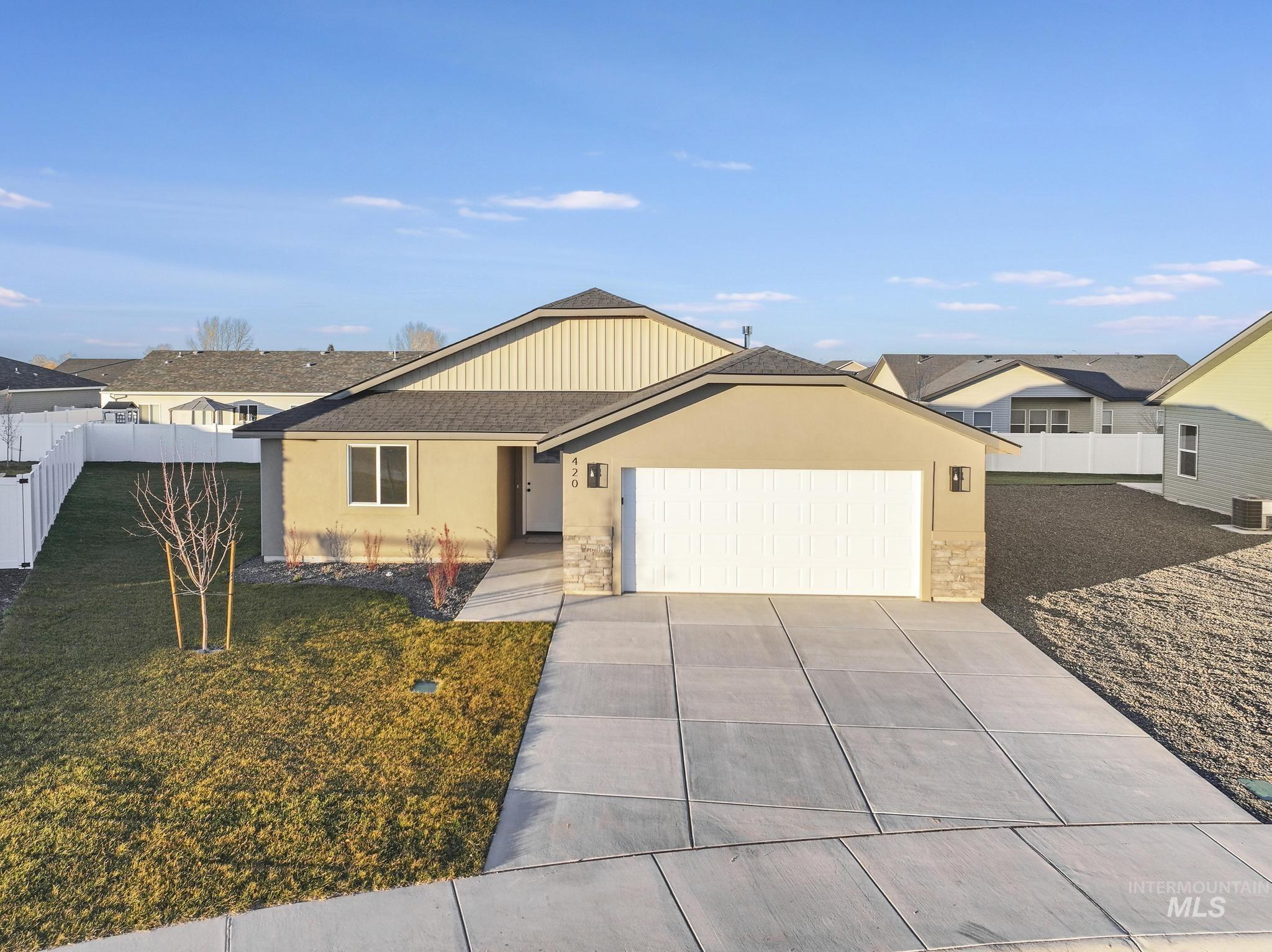 Ranch-style home with stucco siding, driveway, an attached garage, and stone siding