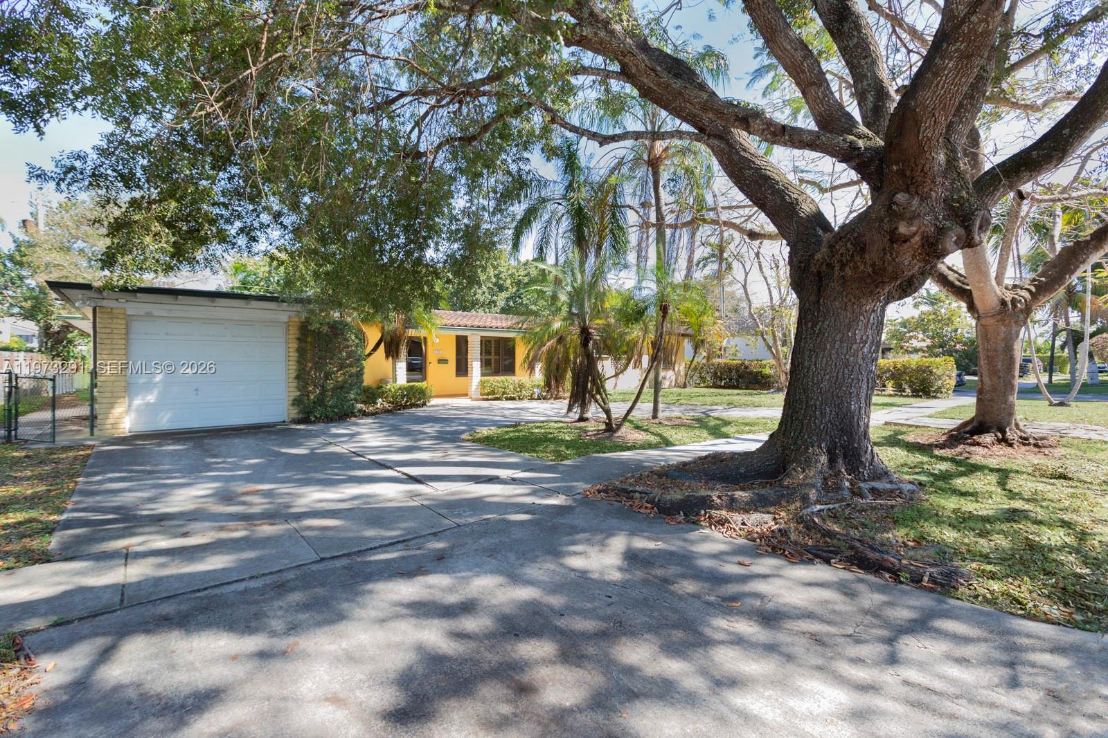 3721 Southwest 58th Avenue Miami, FL 33155 - Photo 1 of 23 a view of a backyard with large tree and wooden fence