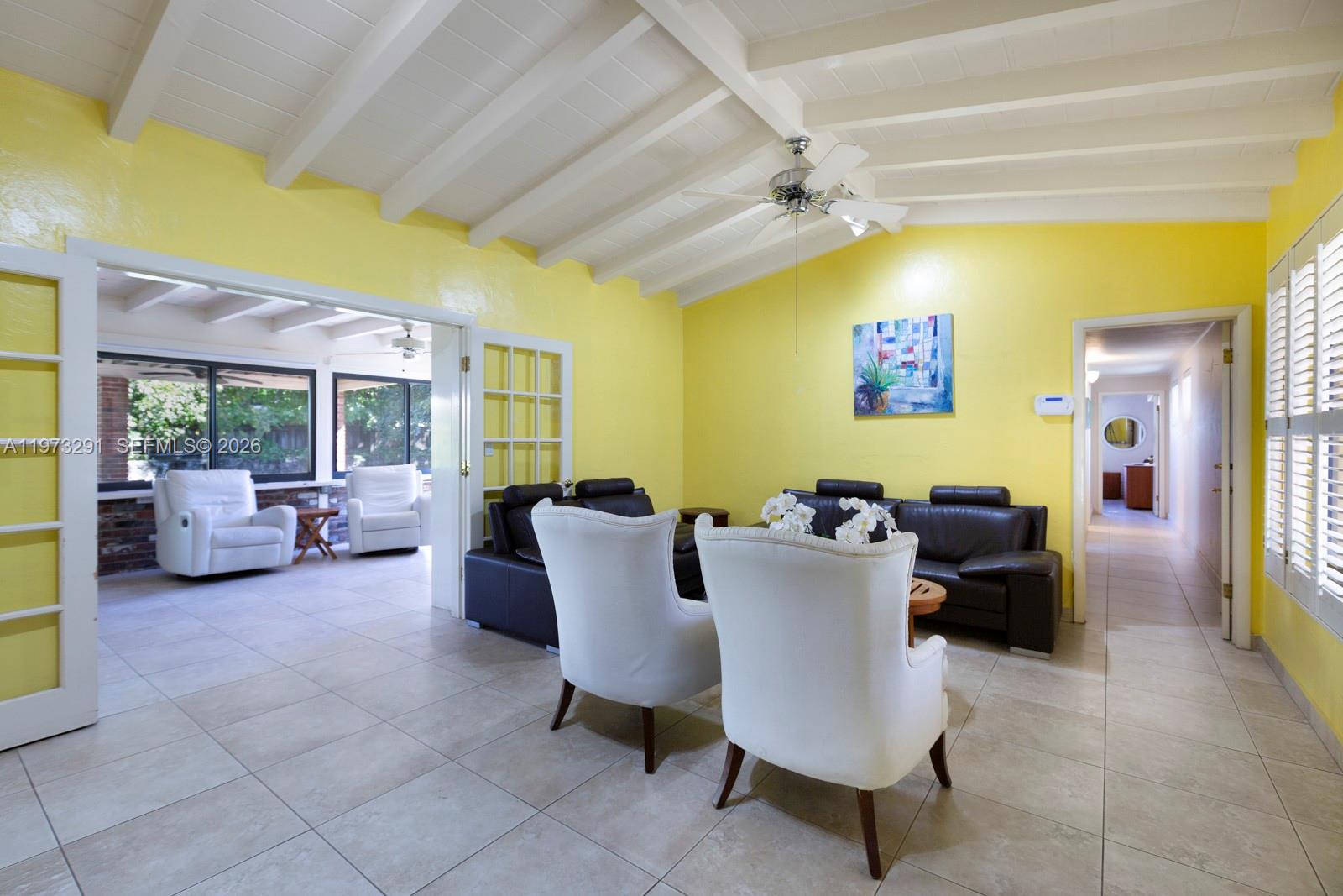 3721 Southwest 58th Avenue Miami, FL 33155 - Photo 2 of 23 a living room with couches and a dining table with a bookshelf next to a window