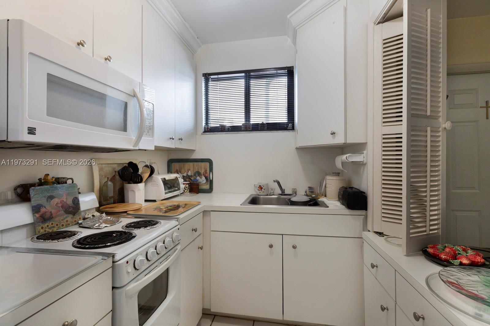 3721 Southwest 58th Avenue Miami, FL 33155 - Photo 21 of 23 a kitchen with cabinets appliances a sink and a microwave