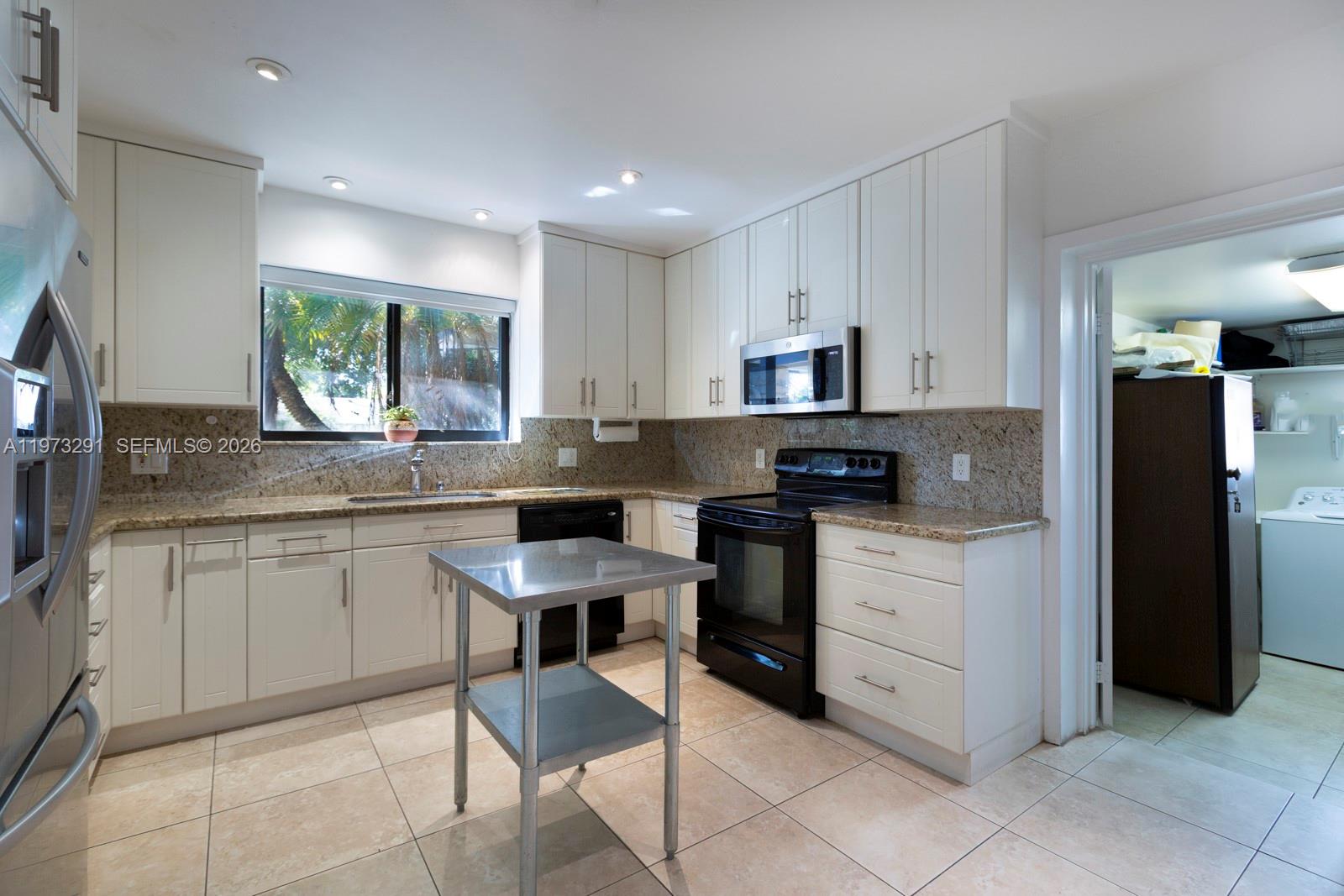 3721 Southwest 58th Avenue Miami, FL 33155 - Photo 9 of 23 a kitchen with stainless steel appliances granite countertop a stove a sink and a refrigerator