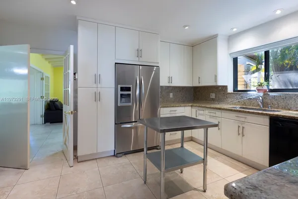 a kitchen with a refrigerator a sink and a stove top oven