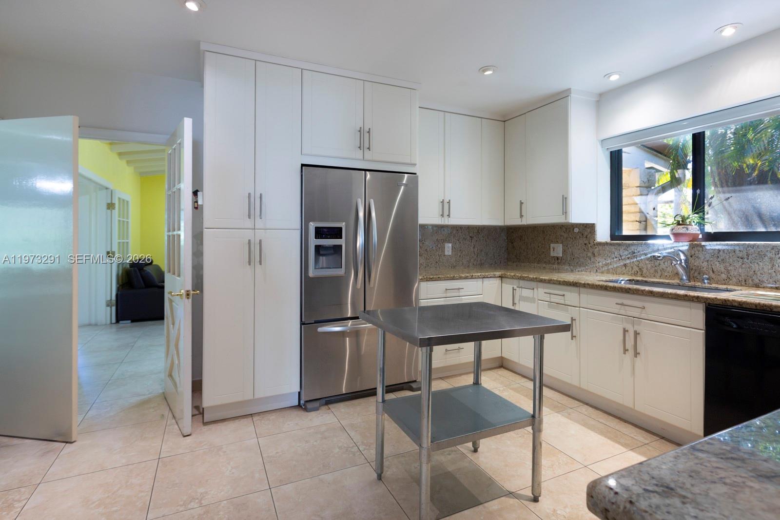 3721 Southwest 58th Avenue Miami, FL 33155 - Photo 10 of 23 a kitchen with a refrigerator a sink and a stove top oven