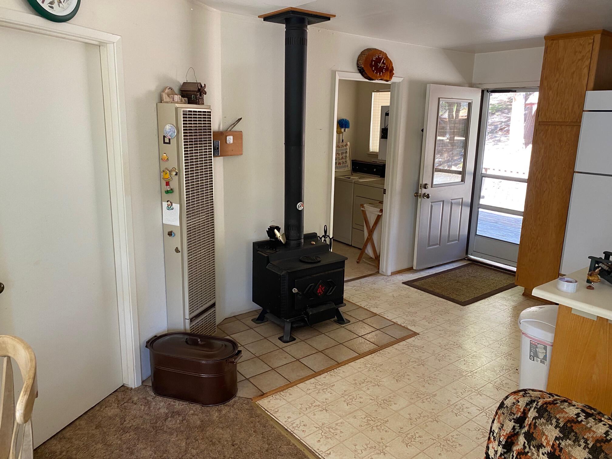581 Mountain Aire Road Trinity Center, CA 96091 - Photo 25 of 48 Wood stove with bedroom door on left and laundry/bathroom door on right