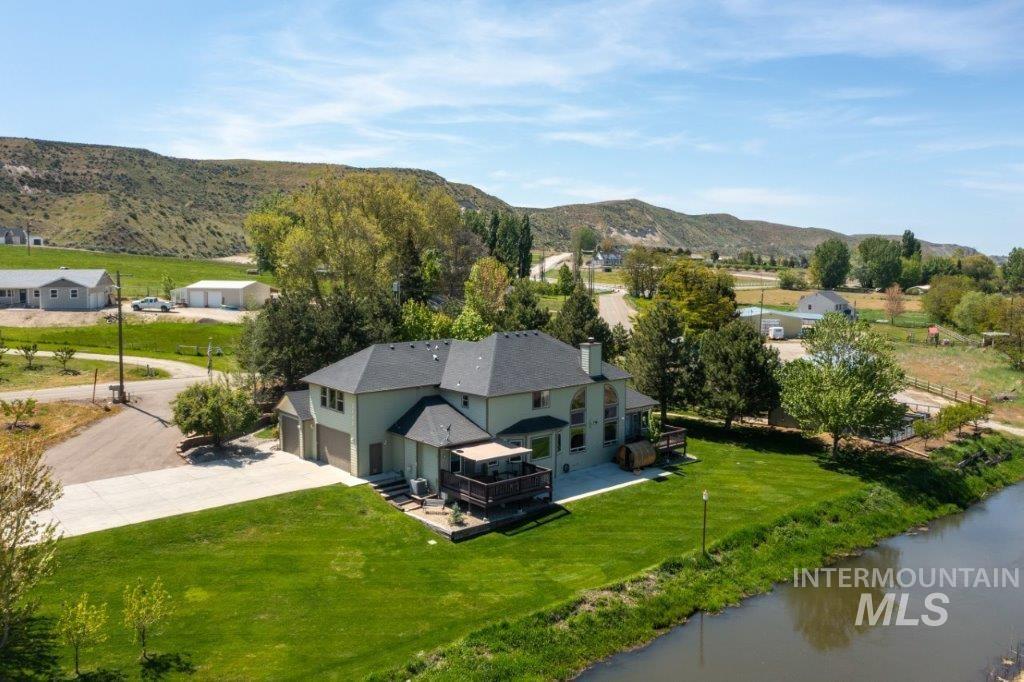 Aerial view of property and surrounding area with a mountainous background