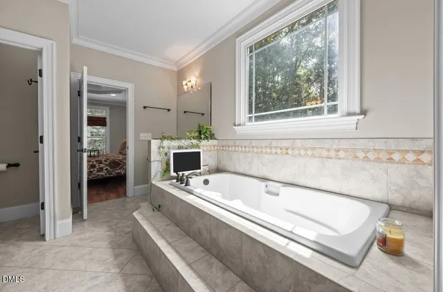 a spacious bathroom with a tub sink and mirror