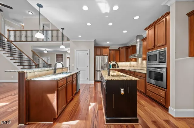 a kitchen with stainless steel appliances granite countertop a stove a sink and a refrigerator
