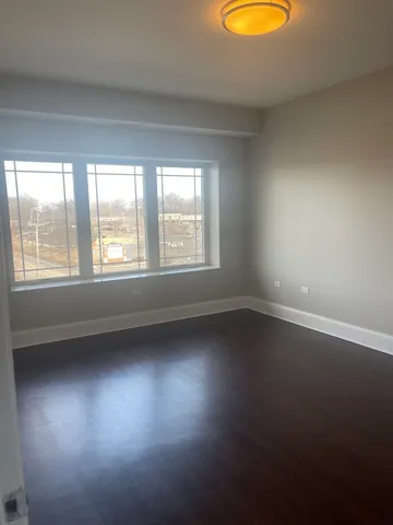 a view of a small space with wooden floor and a window