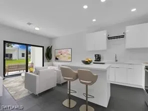 a living room with furniture a flat screen tv and kitchen view