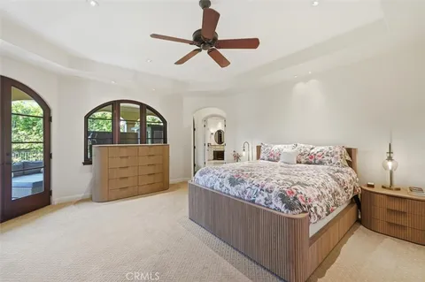a bedroom with a bed a dresser and a large window