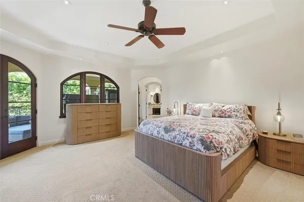 a bedroom with a bed a dresser and a large window