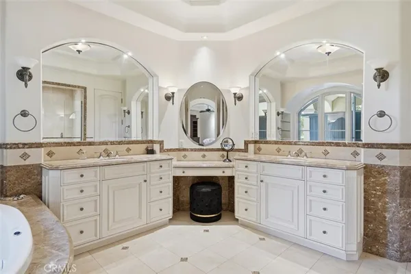 a spacious bathroom with a granite countertop double vanity sink and a mirror