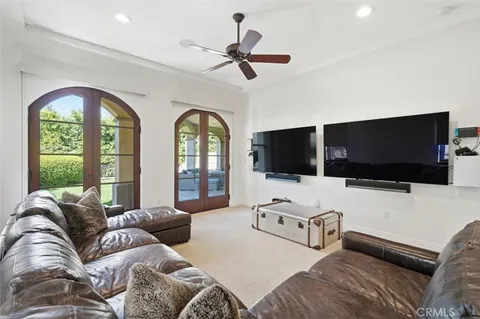 a living room with furniture a flat screen tv and a large window