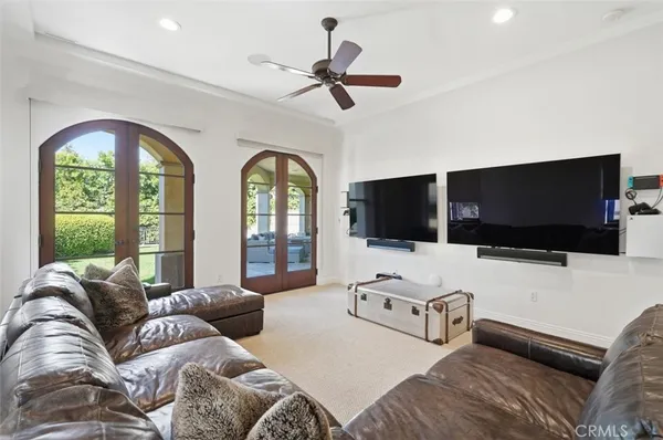 a living room with furniture a flat screen tv and a large window