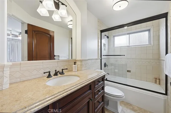 a bathroom with a granite countertop sink toilet and shower