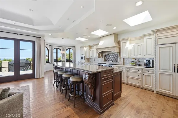 a kitchen with stainless steel appliances granite countertop a kitchen island a stove a table and chairs in it