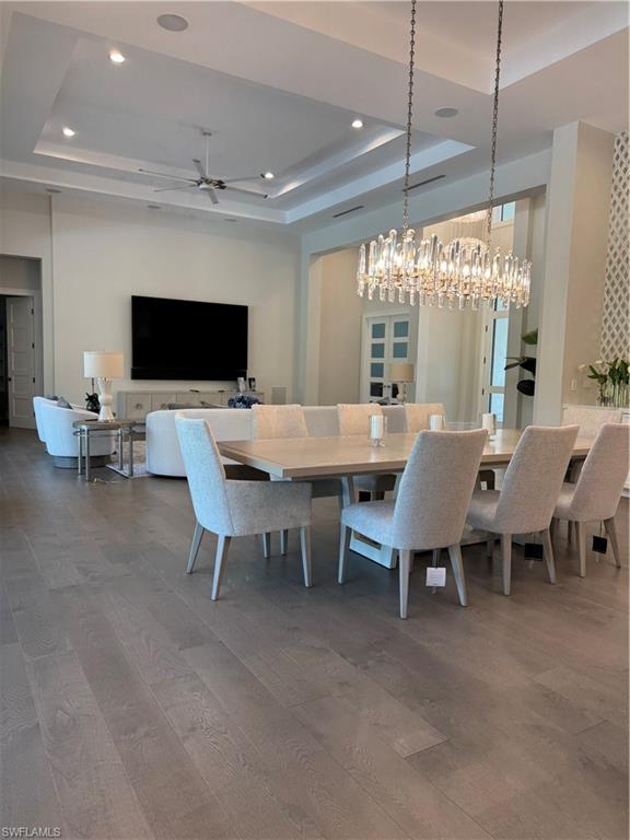 569 Neapolitan Way Naples, FL 34103 - Photo 6 of 50 Dining room with recessed lighting, a raised ceiling, and wood finished floors