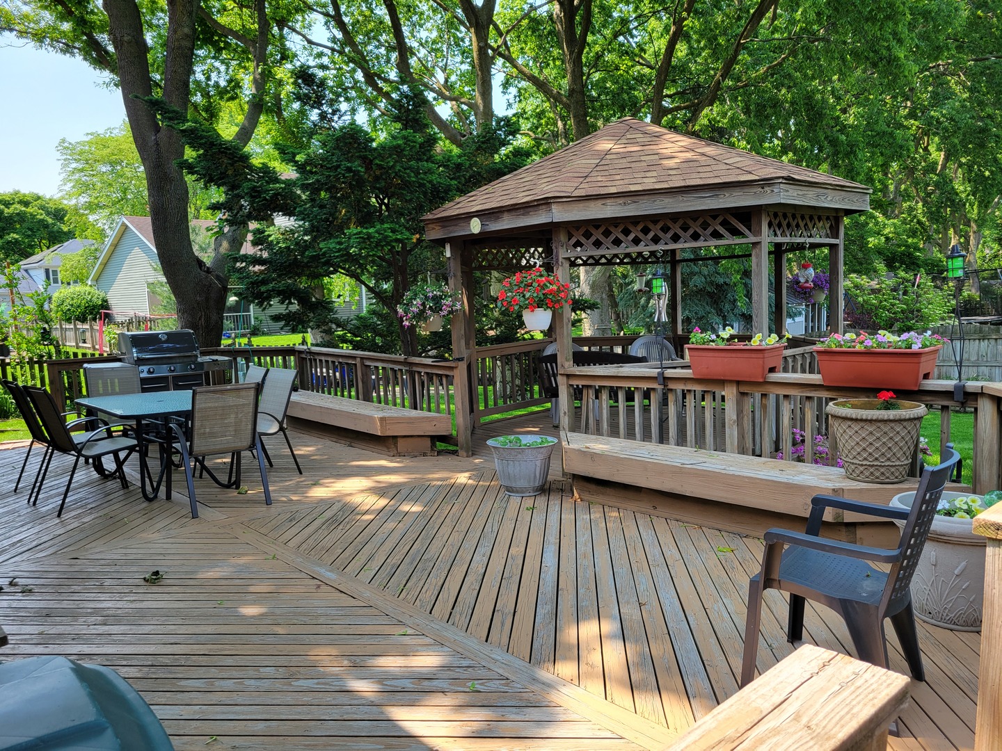 1263 Bainbridge Drive Naperville, IL 60563 - Photo 29 of 31 a view of a roof deck with table and chairs under an umbrella with wooden floor