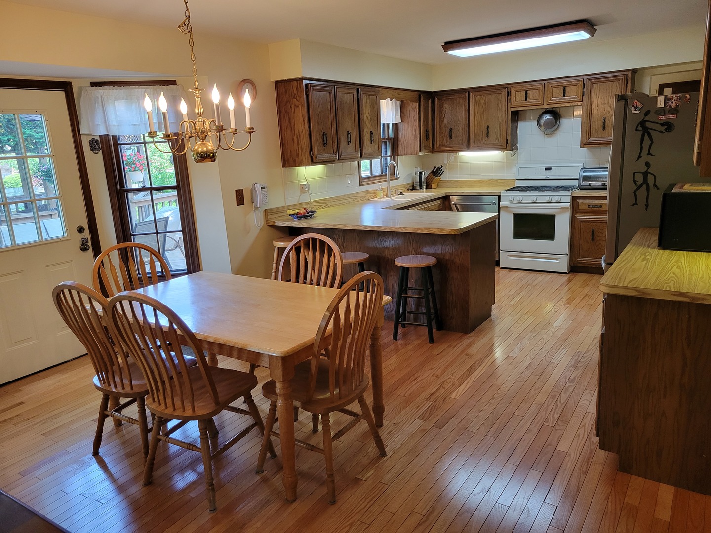 1263 Bainbridge Drive Naperville, IL 60563 - Photo 3 of 31 a kitchen with a kitchen island hardwood floor sink stove dining table and chairs
