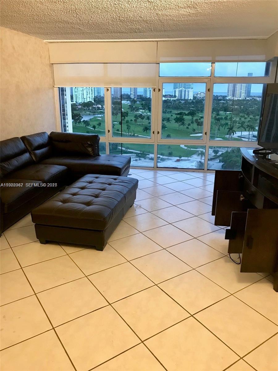 20100 West Country Club Drive, Unit 1606 Aventura, FL 33180 - Photo 7 of 10 a living room with furniture and a floor to ceiling window