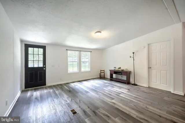 an empty room with windows and a fireplace