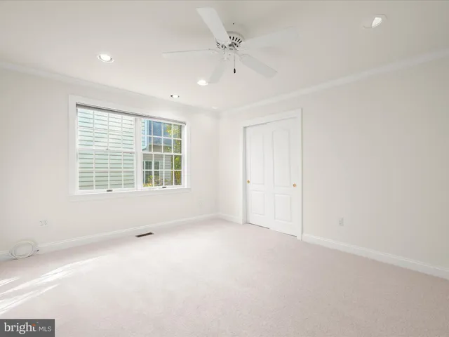 a spacious bedroom with a large bed and a chandelier