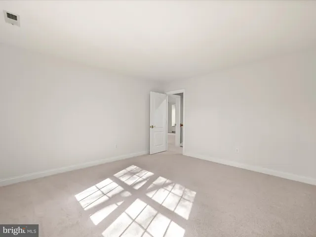 an empty room with windows and chandelier fan
