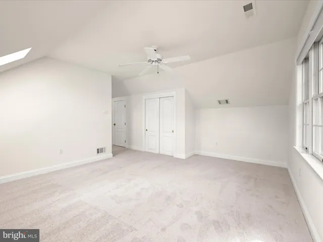 a view of an empty room with wooden floor and windows