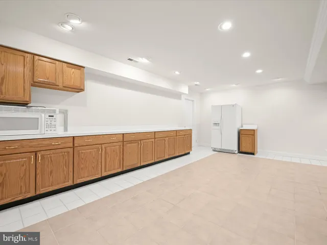a backyard of a house with a large tree and wooden fence