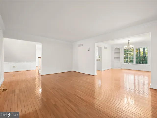 an empty room with wooden floor and window