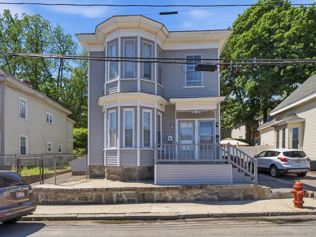 223 Stackpole Street Lowell, MA 01852 - Photo 1 of 42 a front view of a house with garden