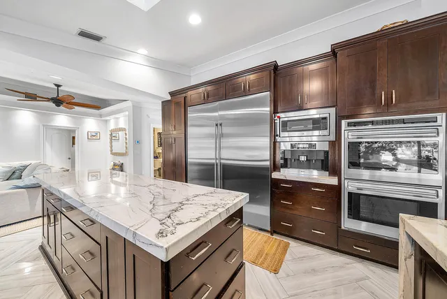 a living room with furniture kitchen view and a wooden floor