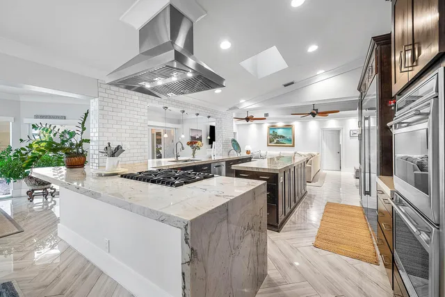 a living room with furniture a ceiling fan a flat screen tv and a fireplace
