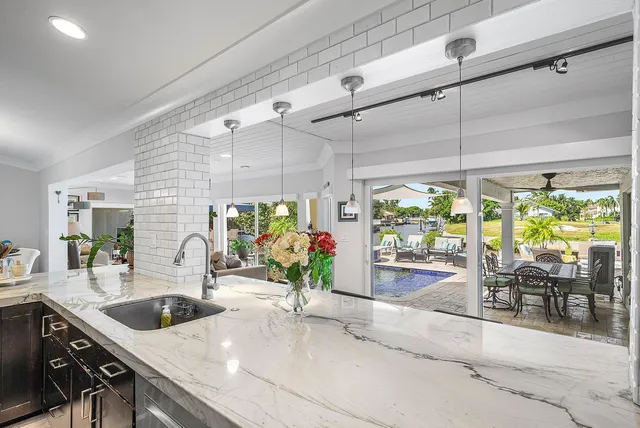 a living room with furniture floor to ceiling window and a flat screen tv