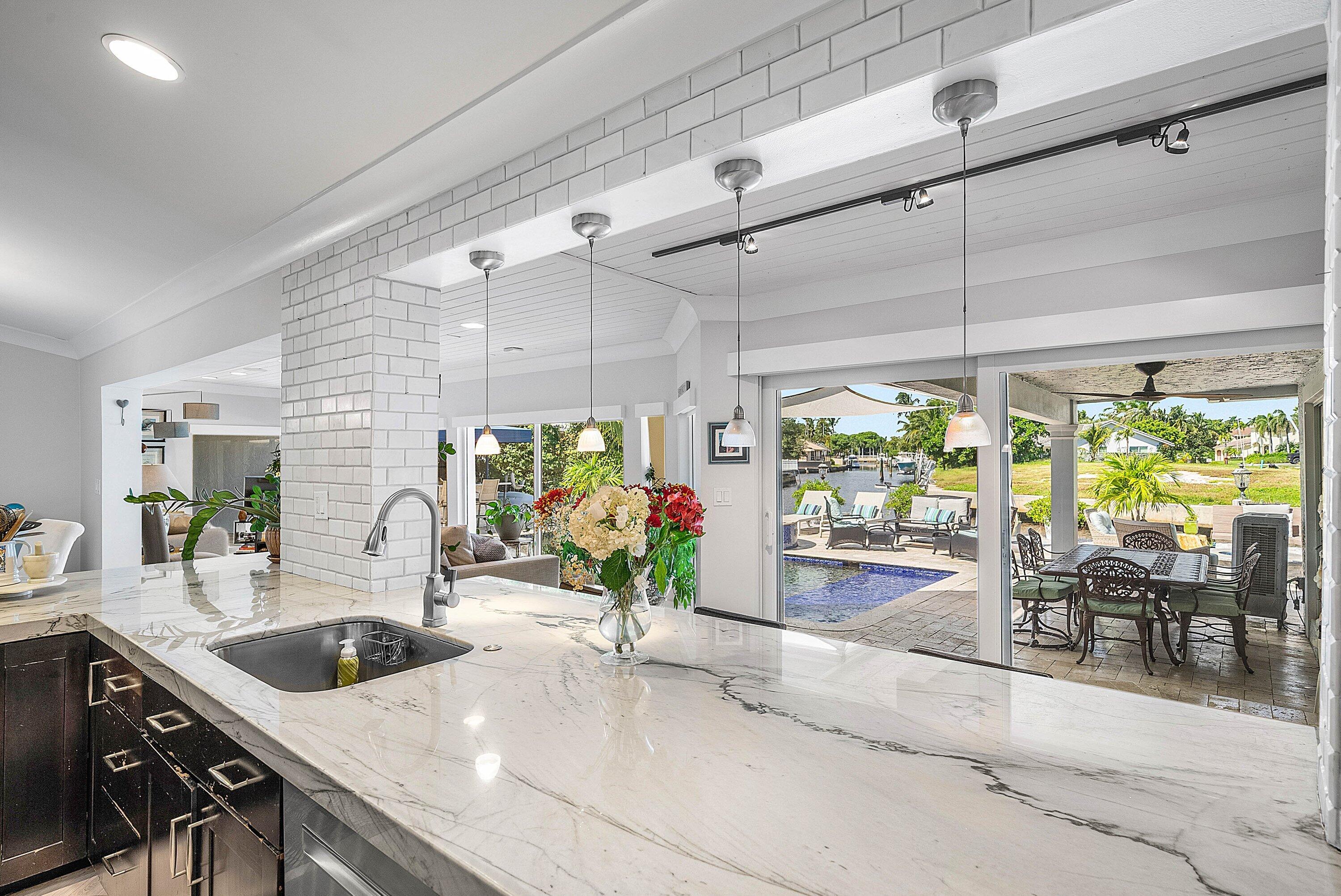 7425 Northeast Bay Cove Court Boca Raton, FL 33487 - Photo 17 of 86 a kitchen with a sink and wooden cabinets