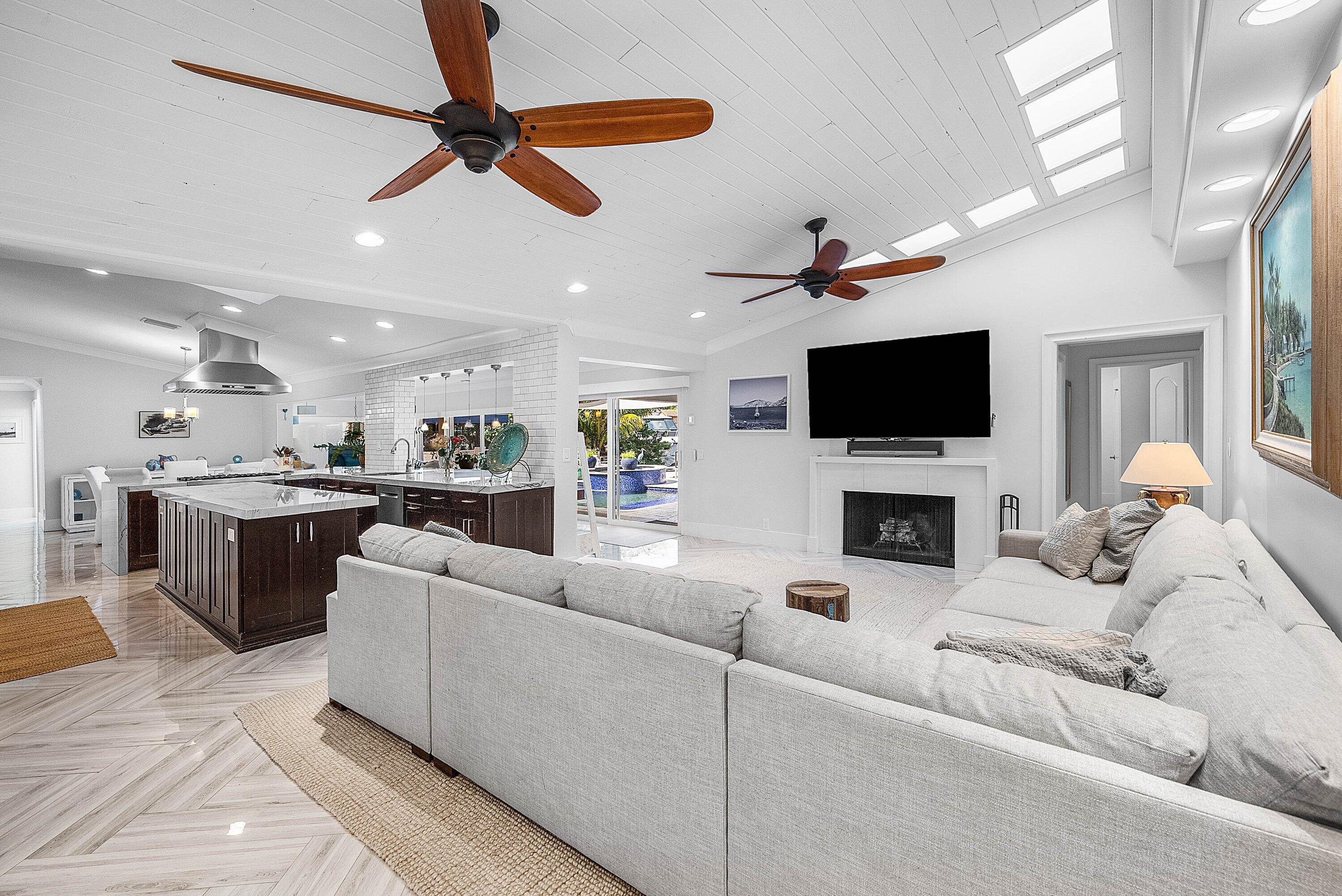 7425 Northeast Bay Cove Court Boca Raton, FL 33487 - Photo 23 of 86 a living room with furniture a ceiling fan a flat screen tv and a fireplace