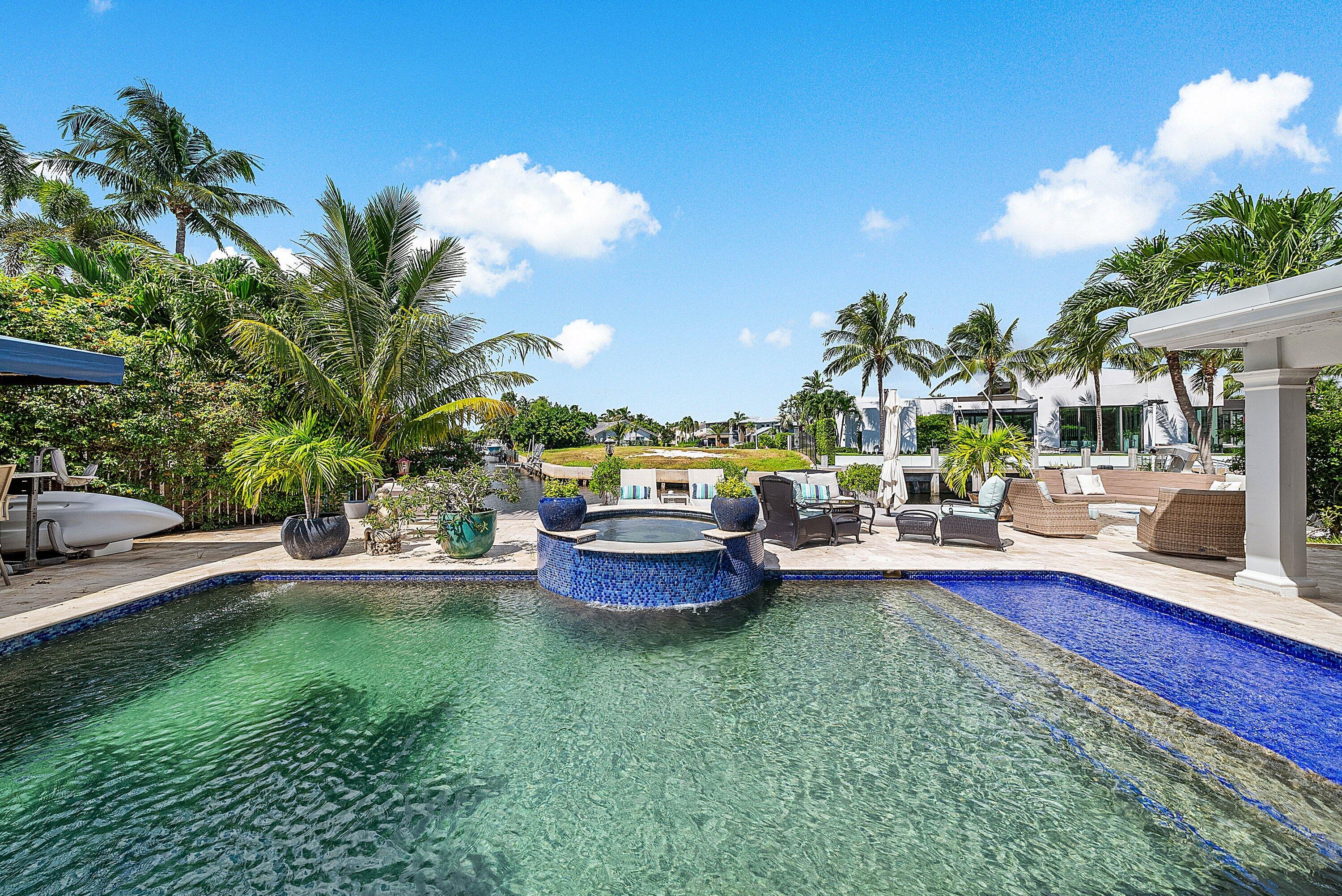 7425 Northeast Bay Cove Court Boca Raton, FL 33487 - Photo 29 of 86 a view of a swimming pool and lounge chairs in back yard of the house