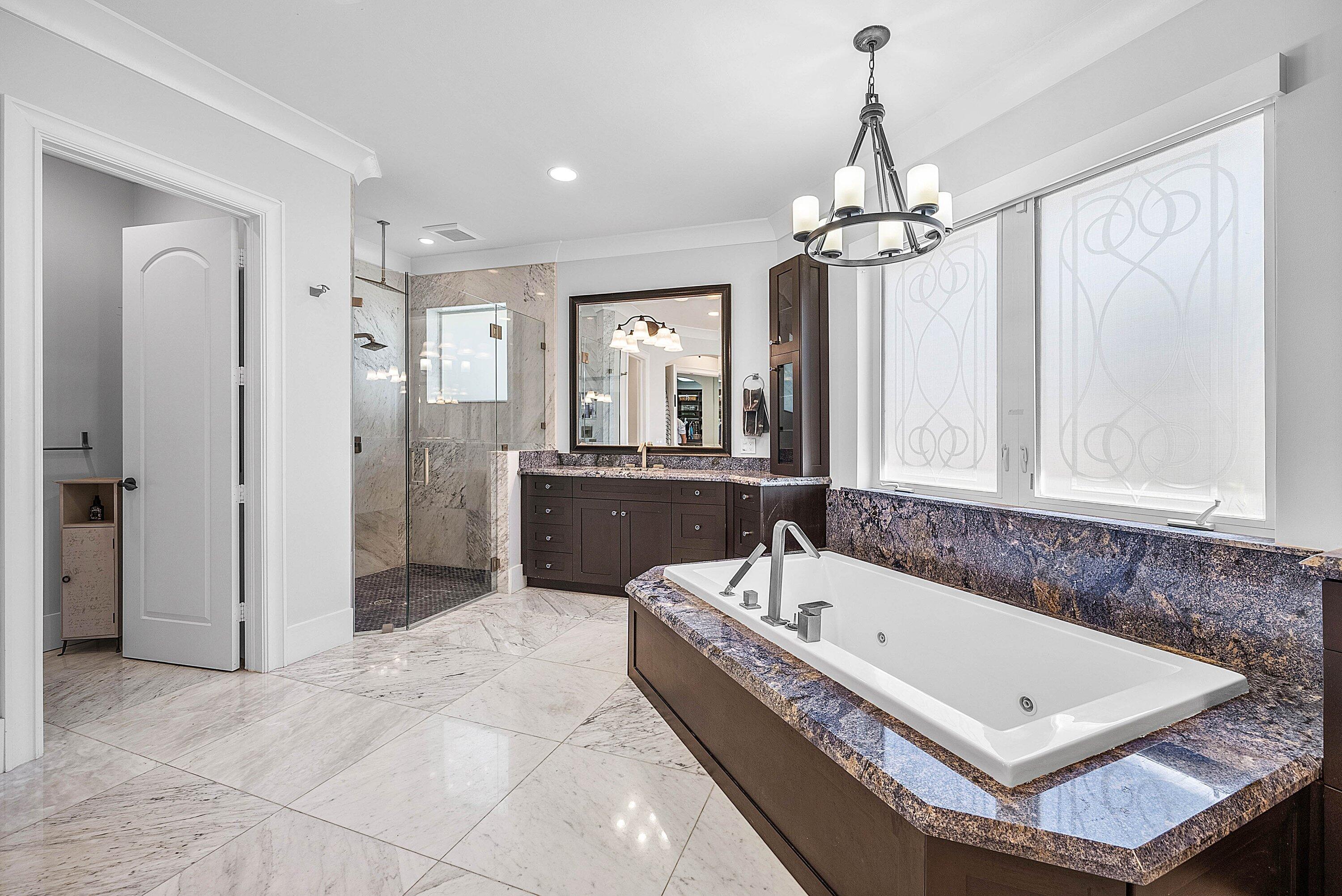 7425 Northeast Bay Cove Court Boca Raton, FL 33487 - Photo 40 of 86 a view of a bathroom with a tub a double vanity sink a mirror and a shower