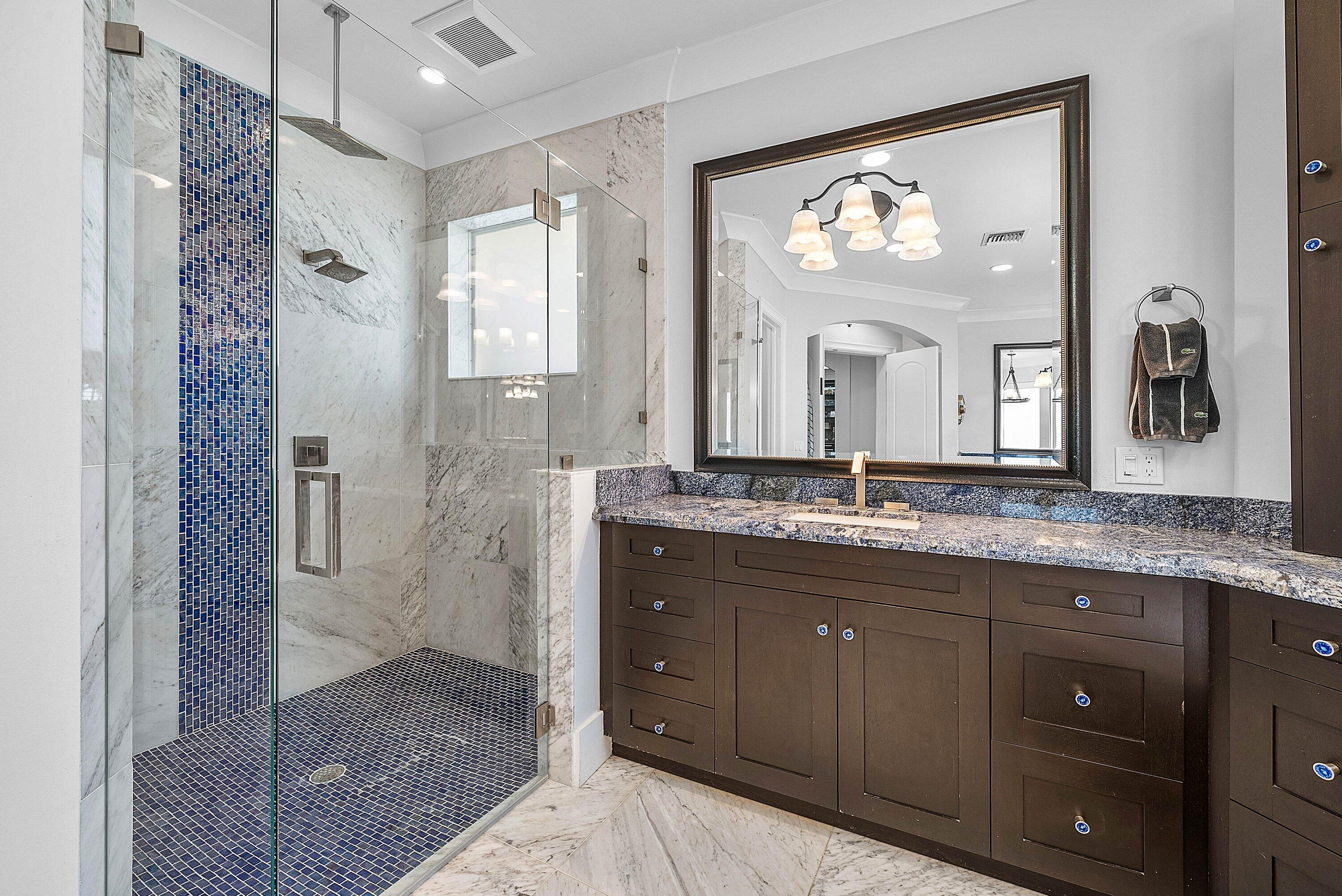 7425 Northeast Bay Cove Court Boca Raton, FL 33487 - Photo 41 of 86 a bathroom with a granite countertop sink a mirror and a shower