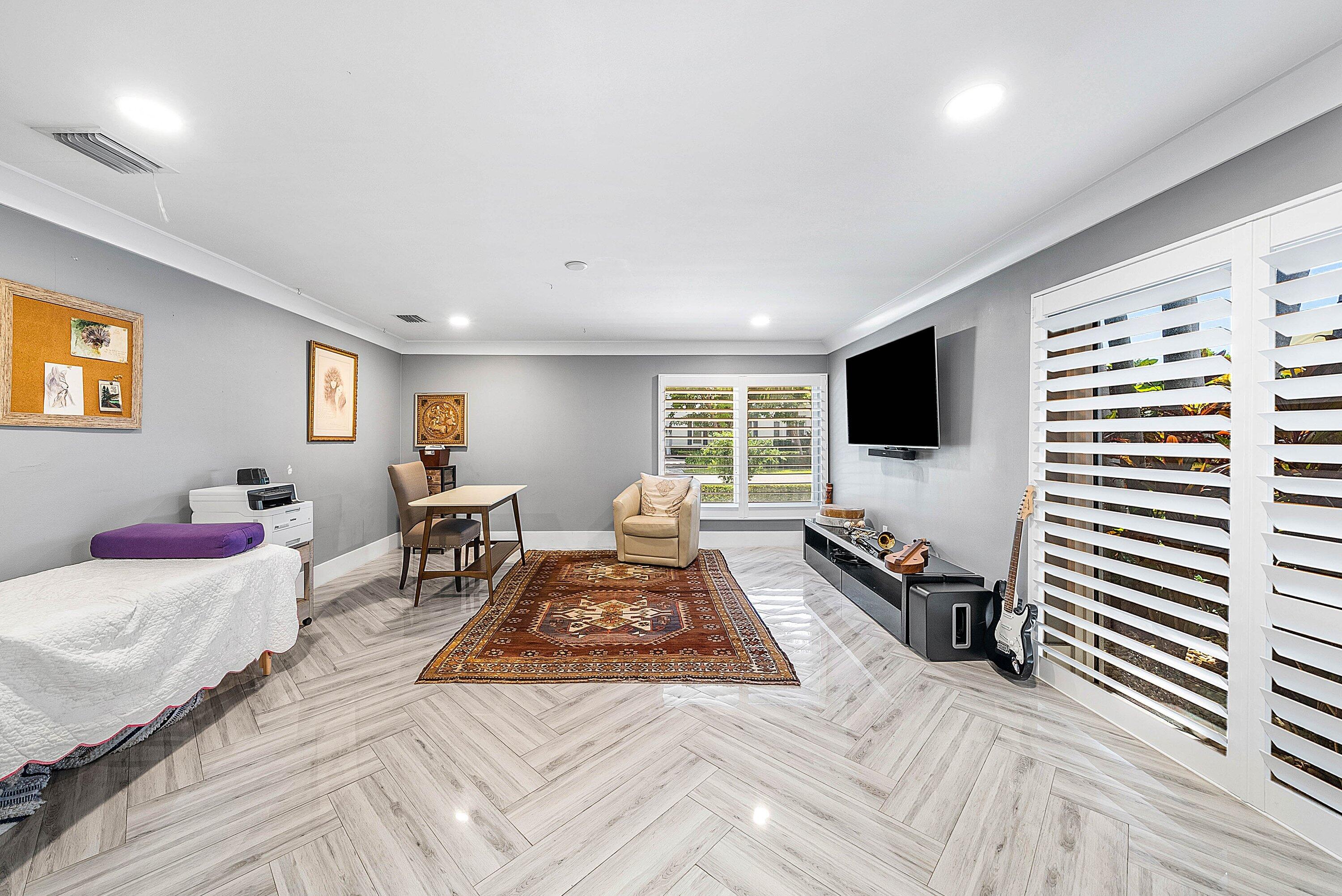 7425 Northeast Bay Cove Court Boca Raton, FL 33487 - Photo 47 of 86 a bed room with furniture and a flat screen tv